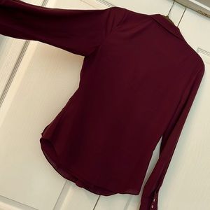 Chiffon wrap blouse with snap closure at waist. Tailored fit